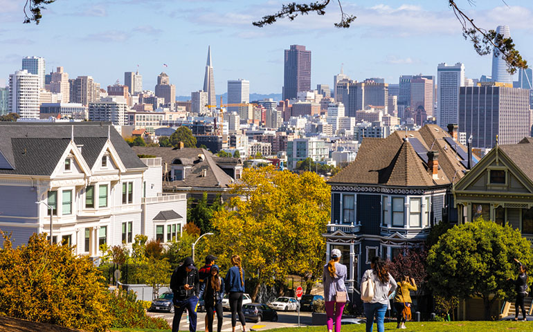 Image of downtown San Francisco on top of the hill near the Painted Ladies with trees turning in fall colors. 