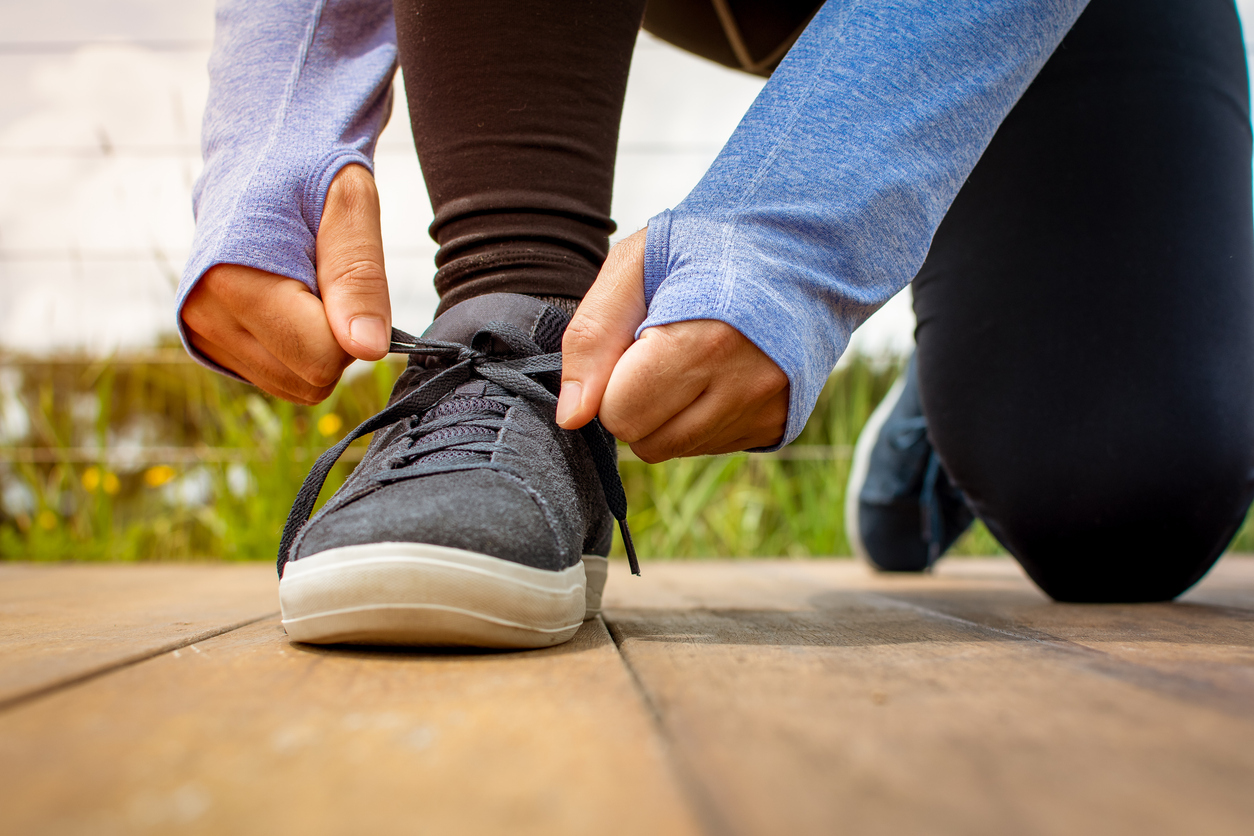 A guy is tying up his sneakers for physical activity