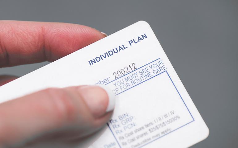 Image of a hand holding a generic insurance ID card that says "Individual Plan"